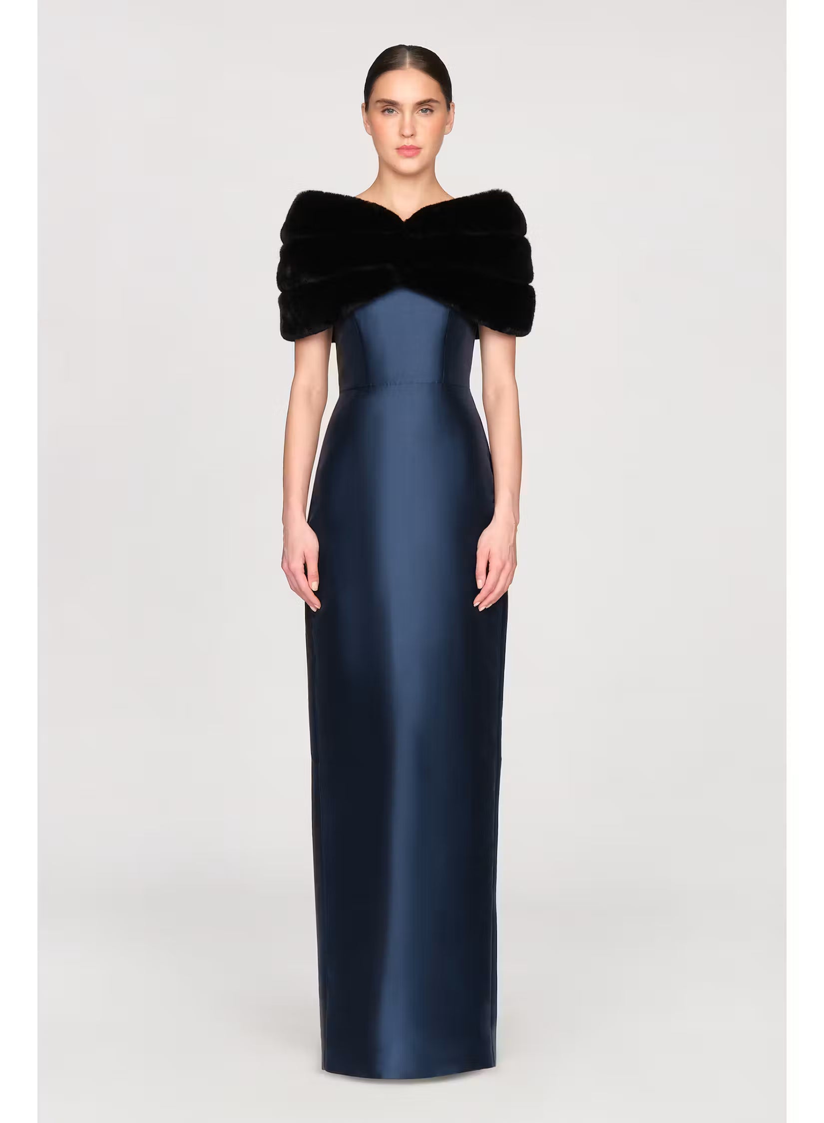 A model poses in a sleek, navy blue gown with a luxurious black faux mink shawl draped over the shoulders, perfect for elegant occasions like a black-tie wedding or gala.