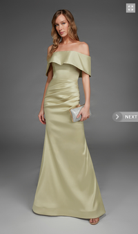 A model showcases a stunning off-the-shoulder gown in a soft yellow hue, featuring a ruffled neckline and a fitted silhouette that flows to the floor. This elegant dress is perfect for special occasions like proms or black tie weddings.