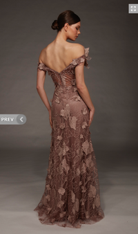 A model showcases a stunning off-the-shoulder gown in a soft cocoa hue, adorned with intricate floral lace details.