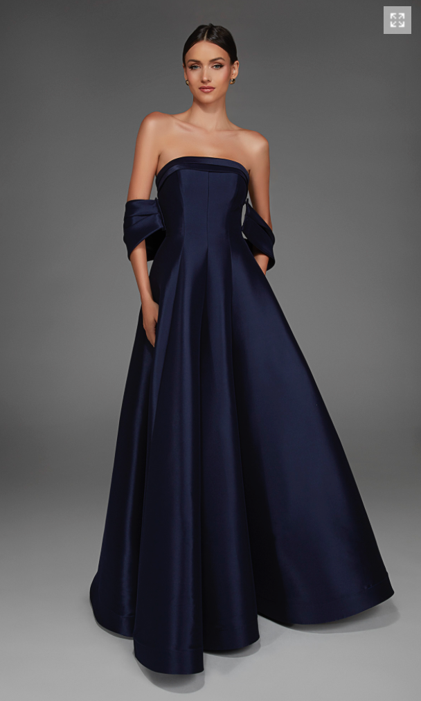 A model showcases a stunning strapless navy gown with an elegant A-line silhouette and dramatic off-the-shoulder sleeves. This sophisticated dress is perfect for formal occasions like galas, black tie weddings, and other special events.