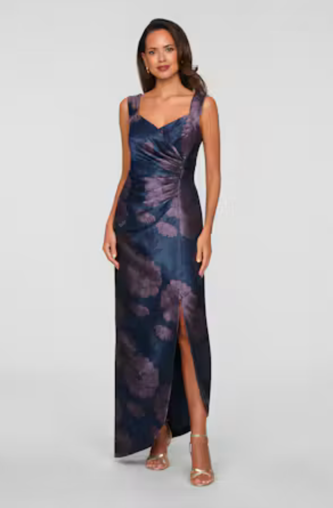 A model showcases a stunning navy and purple floral gown with a sweetheart neckline and a side slit, perfect for elegant events like galas or black-tie weddings. This dress is conveniently available near Apex, Cary, and Raleigh.