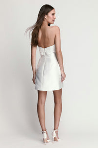 A model showcases a back view of a sleek white dress with a strapless design and lace detailing. This elegant gown is perfect for special occasions like prom or a chic date night, and is conveniently available near Apex, Cary, and Raleigh.