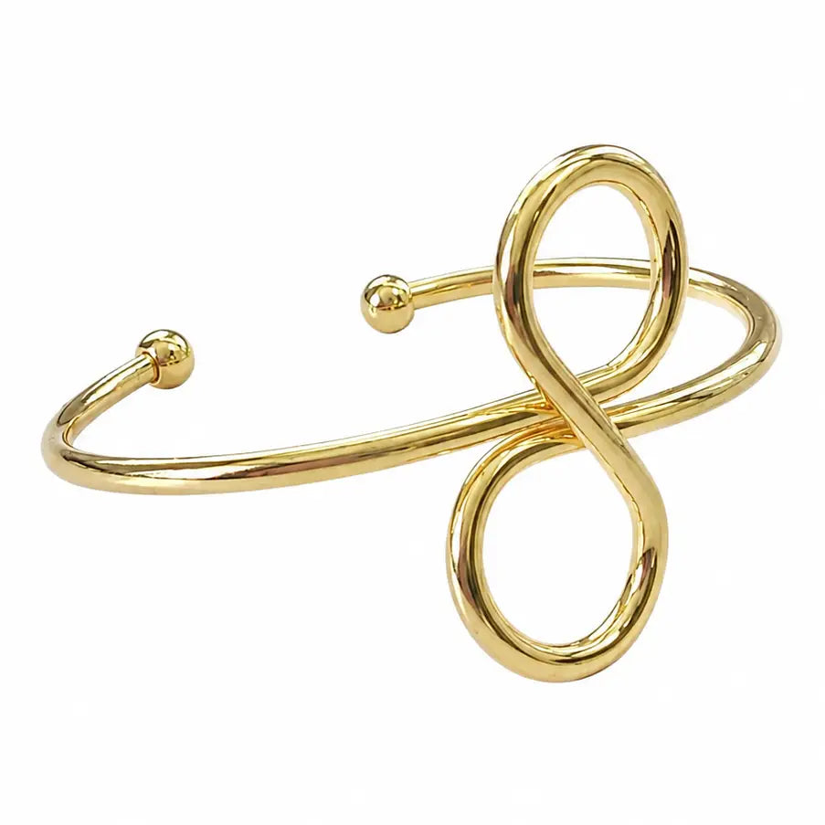 A gold infinity cuff bracelet features a sleek design with a twisted infinity symbol at the center. This elegant accessory is perfect for special occasions like weddings or galas, adding a touch of sophistication to any outfit.