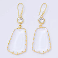Elegant clear stone statement earrings feature a large, irregular-shaped clear stone with gold detailing and a sparkling cubic zirconia at the top. Perfect for adding a touch of glamour to any formal occasion, such as a gala or wedding.
