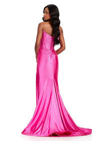 A model showcases a stunning fuchsia strapless gown with a sleek fit and shimmering embellishments. Perfect for events like prom, galas, or black tie weddings, this dress is available near Apex, Cary, and Raleigh.