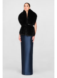 A model elegantly wears a black faux fur stole over a sleek navy gown, showcasing a sophisticated look suitable for formal occasions like black-tie weddings or galas. This stylish stole is available near Apex, Cary, and Raleigh.