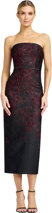 A model stands in a strapless, fitted black dress adorned with intricate burgundy floral embroidery, showcasing a sophisticated look ideal for a gala or black-tie wedding.